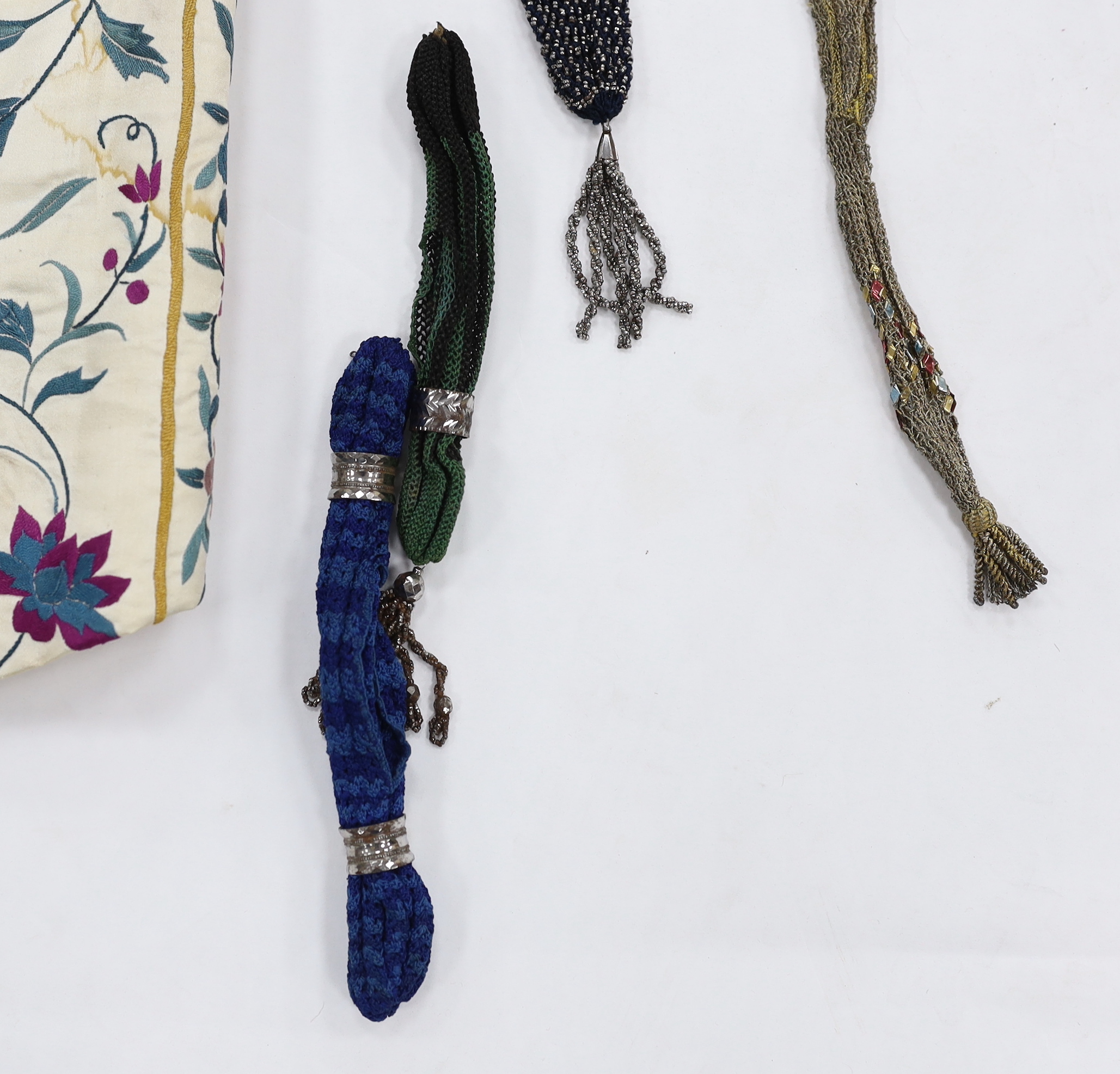 A collection of eight late 18th / early 19th century cut steel and other misers purses, a pair of yellow Regency ladies long shami leather gloves, an exotic feather hat ornament and a Chinese embroidered young boys waist